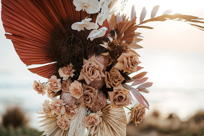 Rust and peach dried wedding flowers, Beachside styled wedding set up, sunpalms,