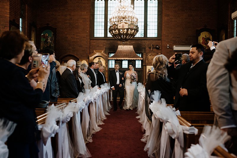 greek wedding ceremony St Catherine's Church, bride coming down aisle